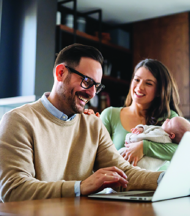 A couple with their baby at a laptop