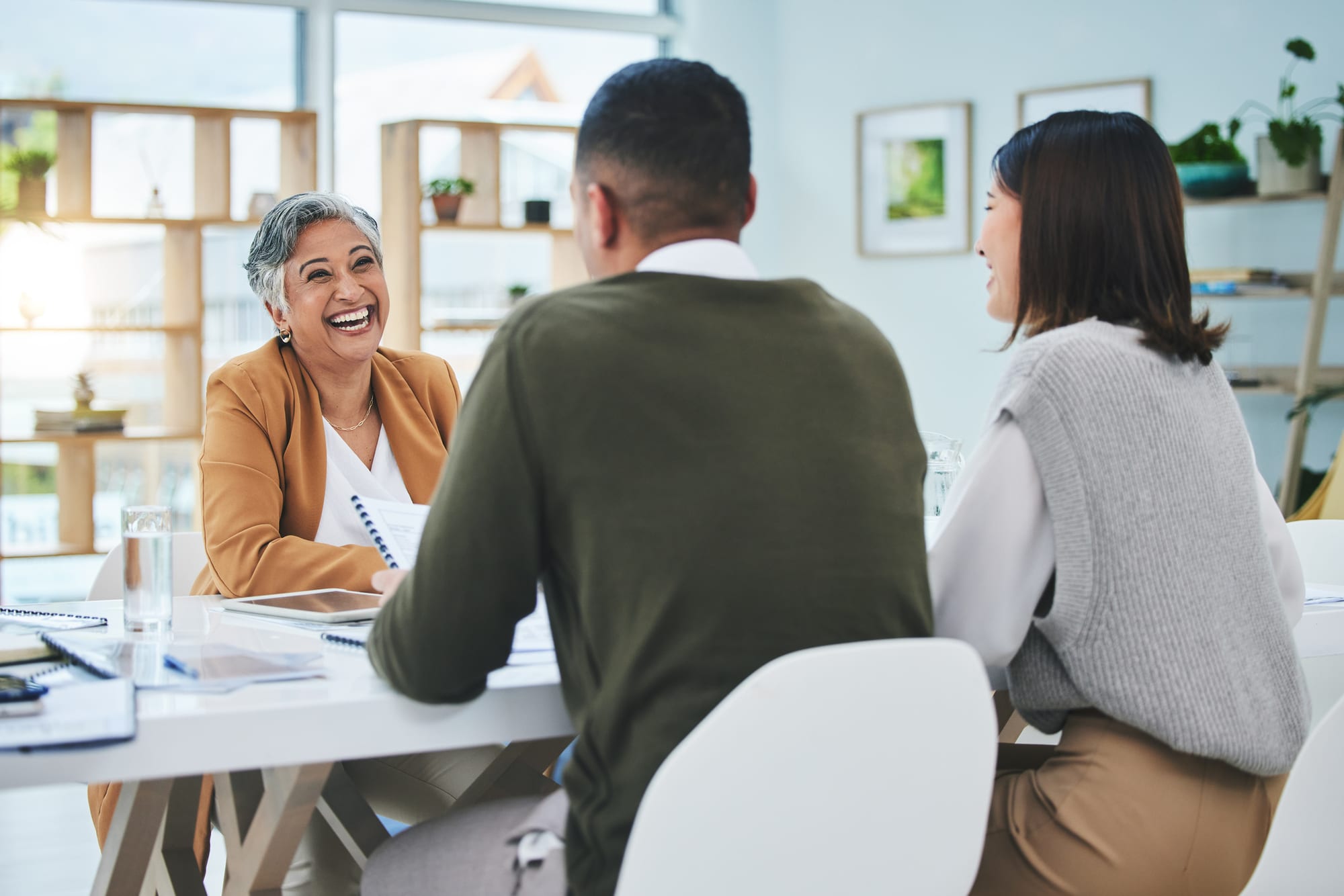 Two people meeting with an adviser across a table