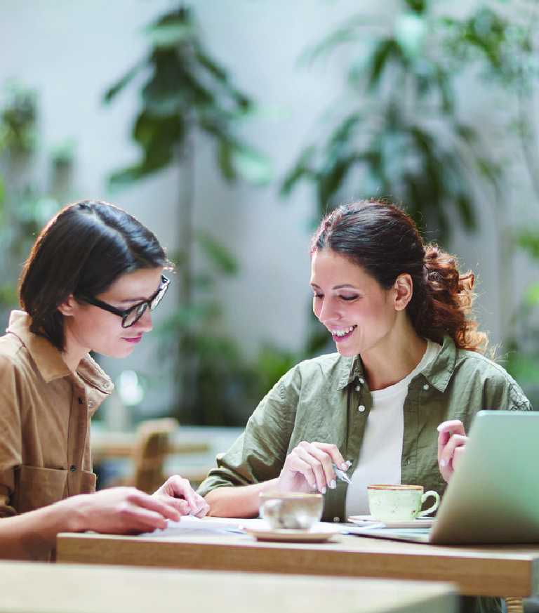 Two women talking over a laptop